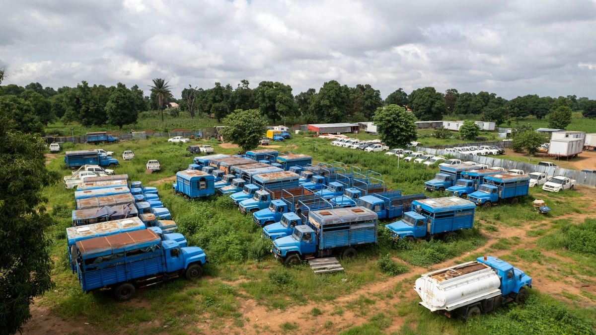 A large fleet of blue haulage trucks parked in a yard, seen from above